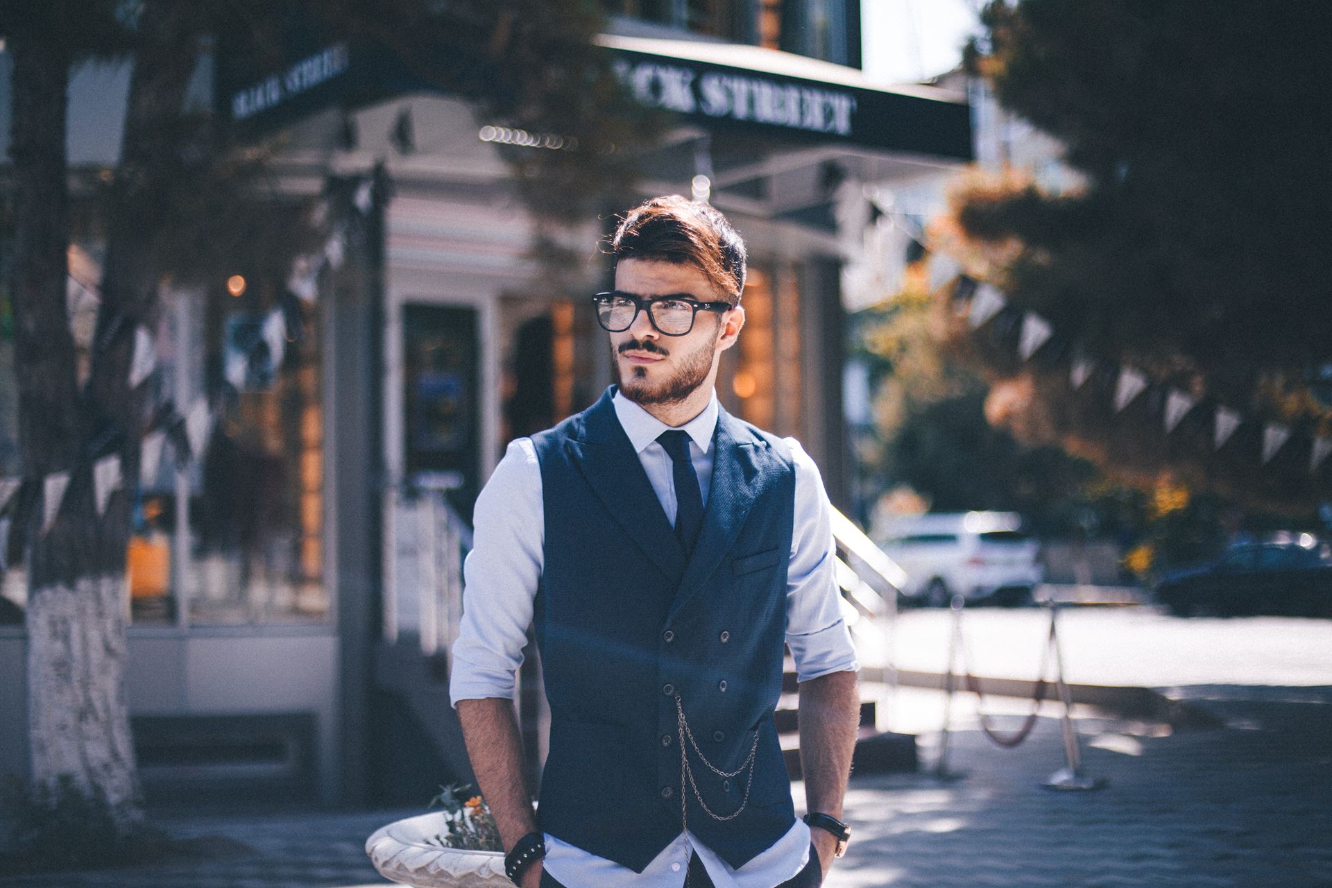 a man wearing a suit and tie walking down the street